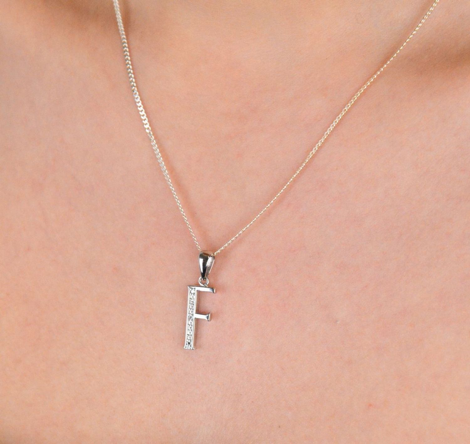 Zawieszka literka F z cyrkoniami próba 925, AP17-0213 F Zawieszka w kształcie literki „F” ozdobiona cyrkoniami to elegancka i subtelna biżuteria wykonana z wysokiej jakości srebra próby 925. 1.jpg